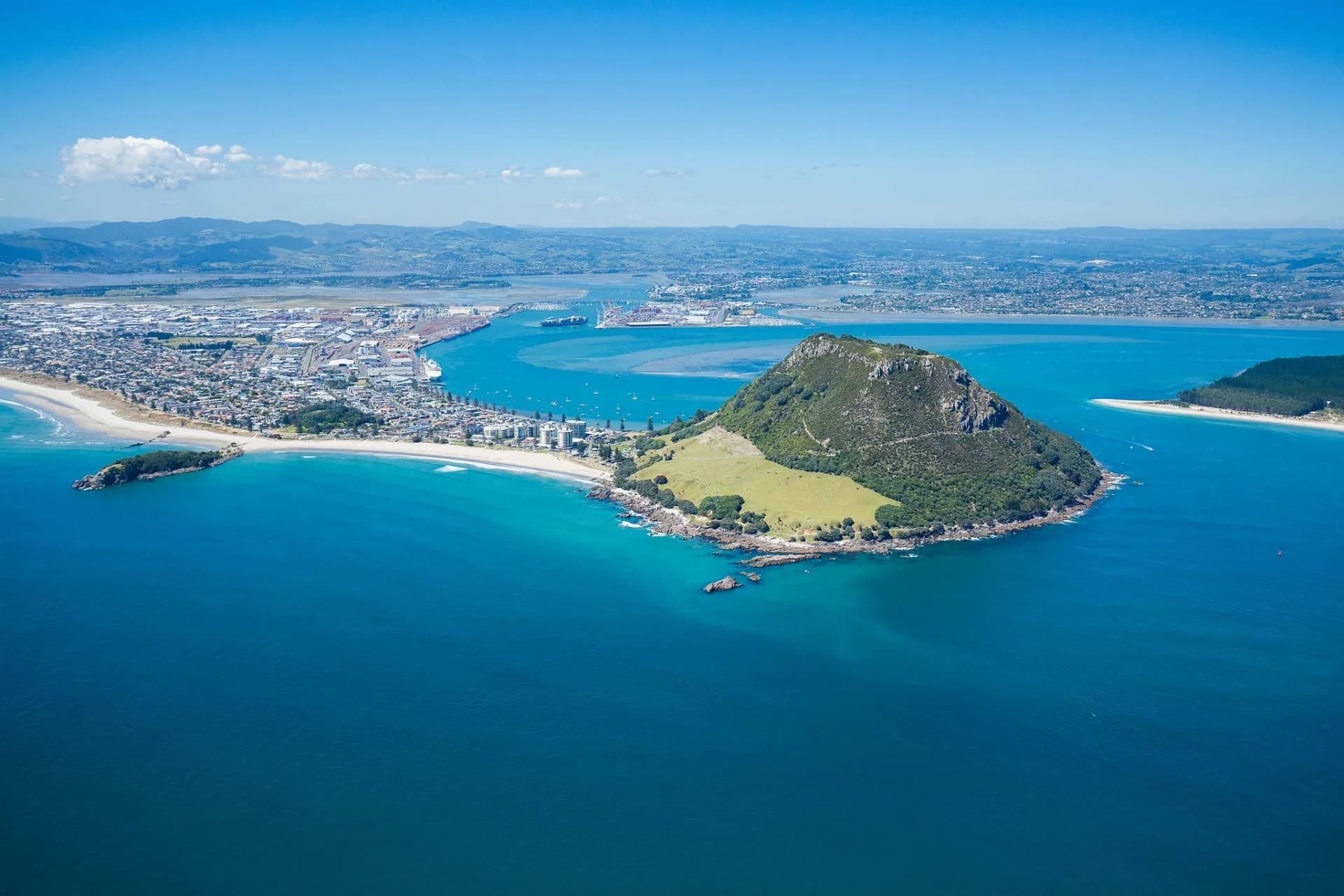 Aerial view of Mount Maunganui headland, beaches, and harbor entrance.