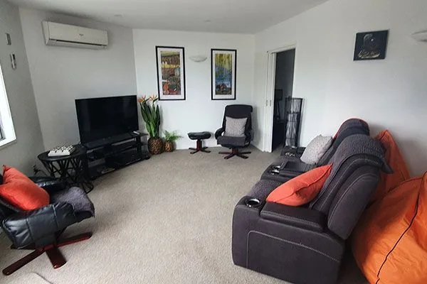 Living room with sectional sofa, recliner chairs, TV, and wall art.