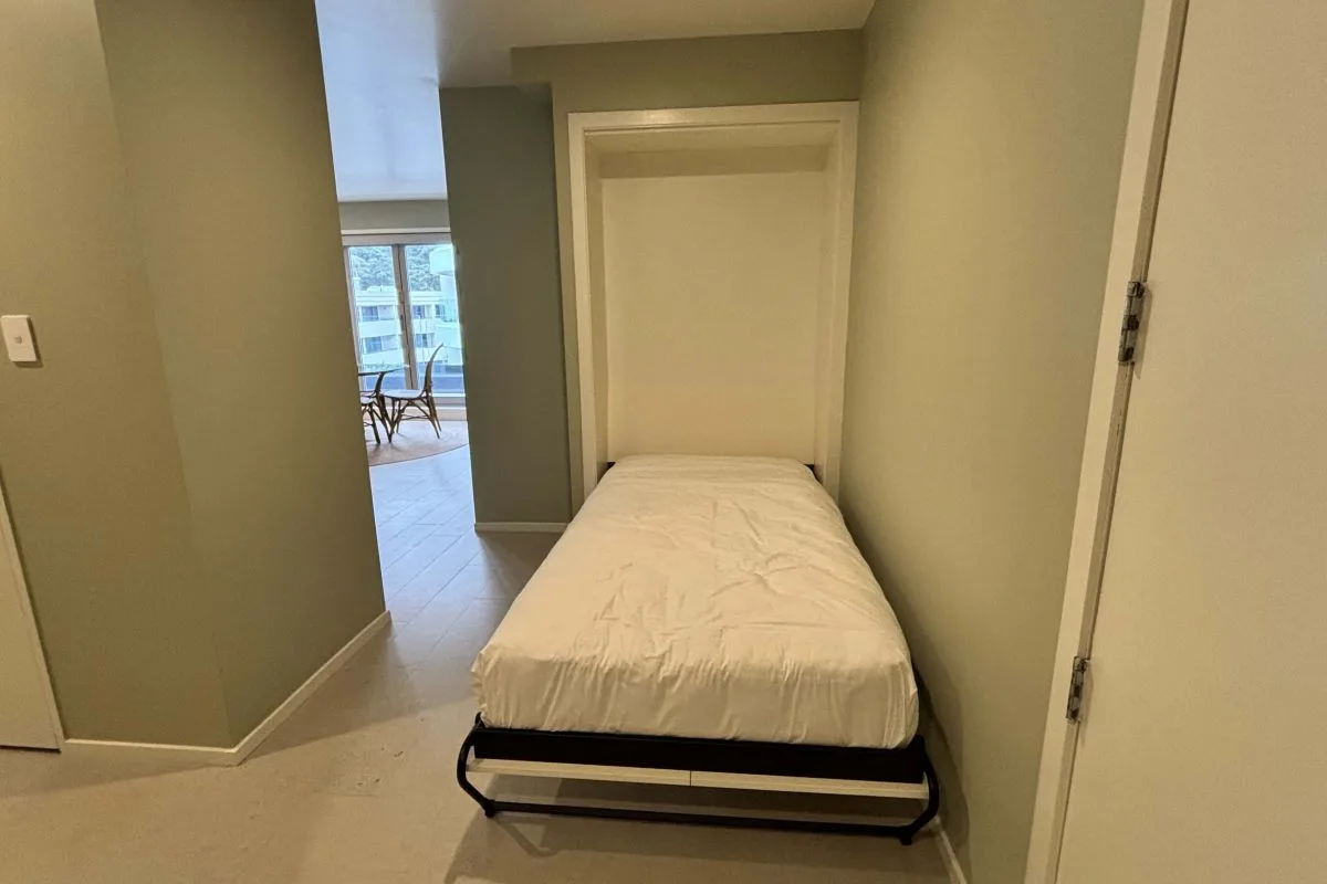 Fold-down single wall bed in a hallway alcove, mattress extended.
